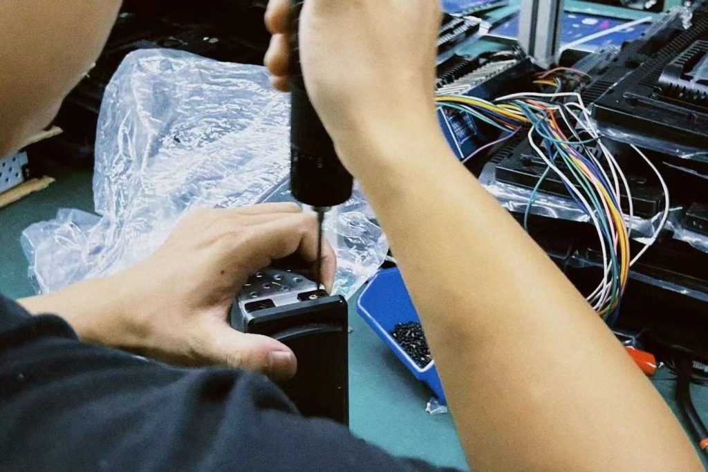 Ein Techniker testet ein fahrzeugspezifisches digitales Kombiinstrument im Rahmen einer Garantieprüfung